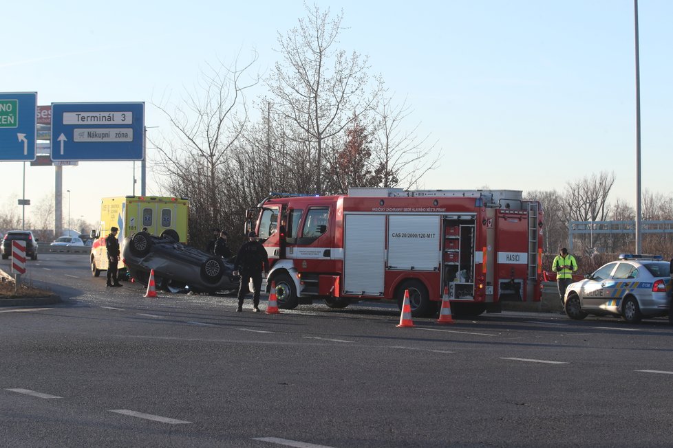 Nedaleko letiště v Praze se po nehodě ocitlo auto na střeše.