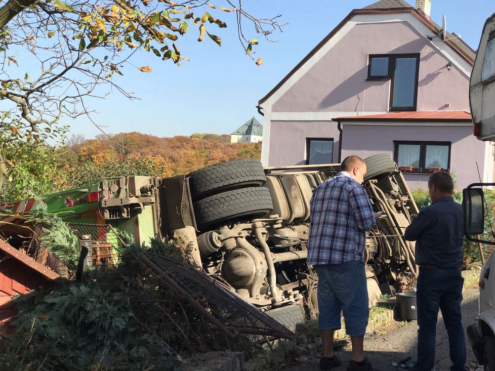 Auto popelářů na Bílé Hoře skončilo na boku v zahradě.