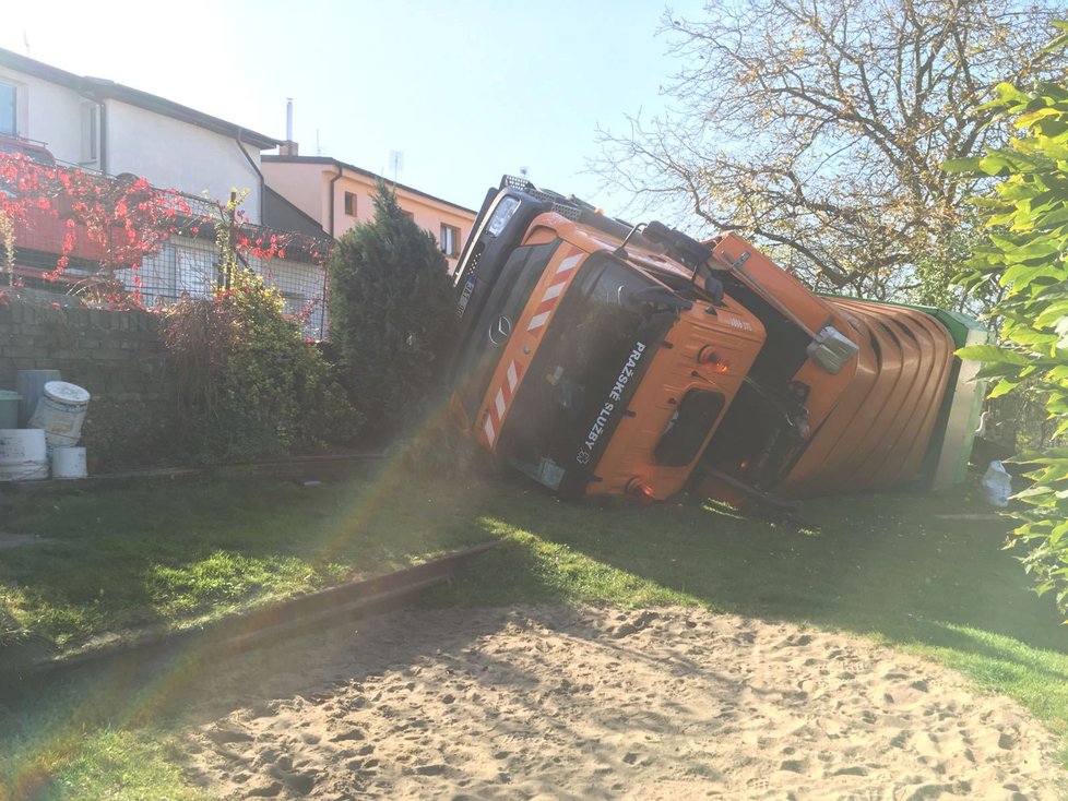 Auto popelářů na Bílé Hoře skončilo na boku v zahradě.