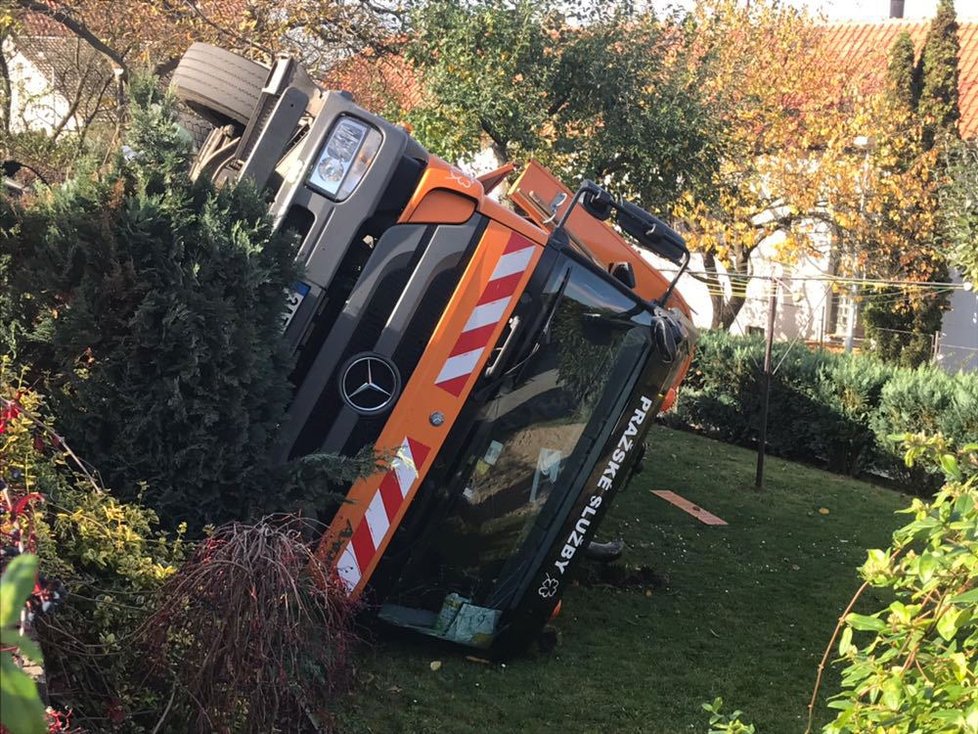 Auto popelářů na Bílé Hoře skončilo na boku v zahradě.