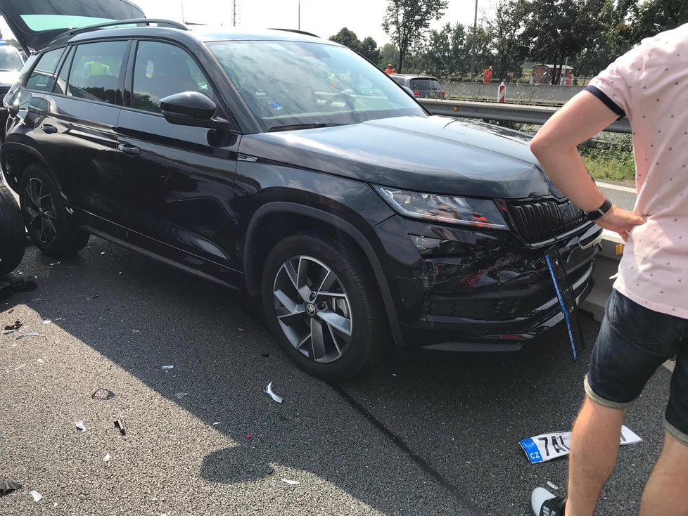 Manžel středočeské hejtmanky Jakub Pokorný(zády v růžovém tričku) si prohlíží své nabourané auto. Zezadu na něj najela herečka Kateřina Brožová