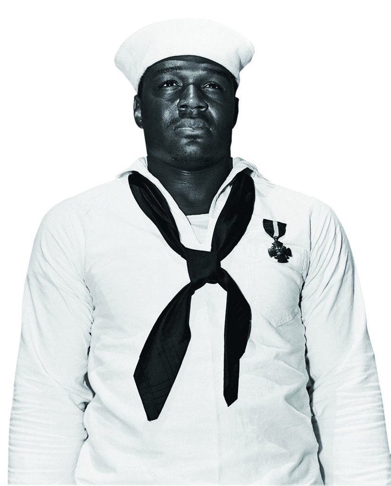 Kuchař Doris Miller získal za své hrdinství vysoké vyznamenání – námořní kříž od admirála Nimitze