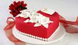 Rudý dort ve tvaru srdce s dekorem bílých květů