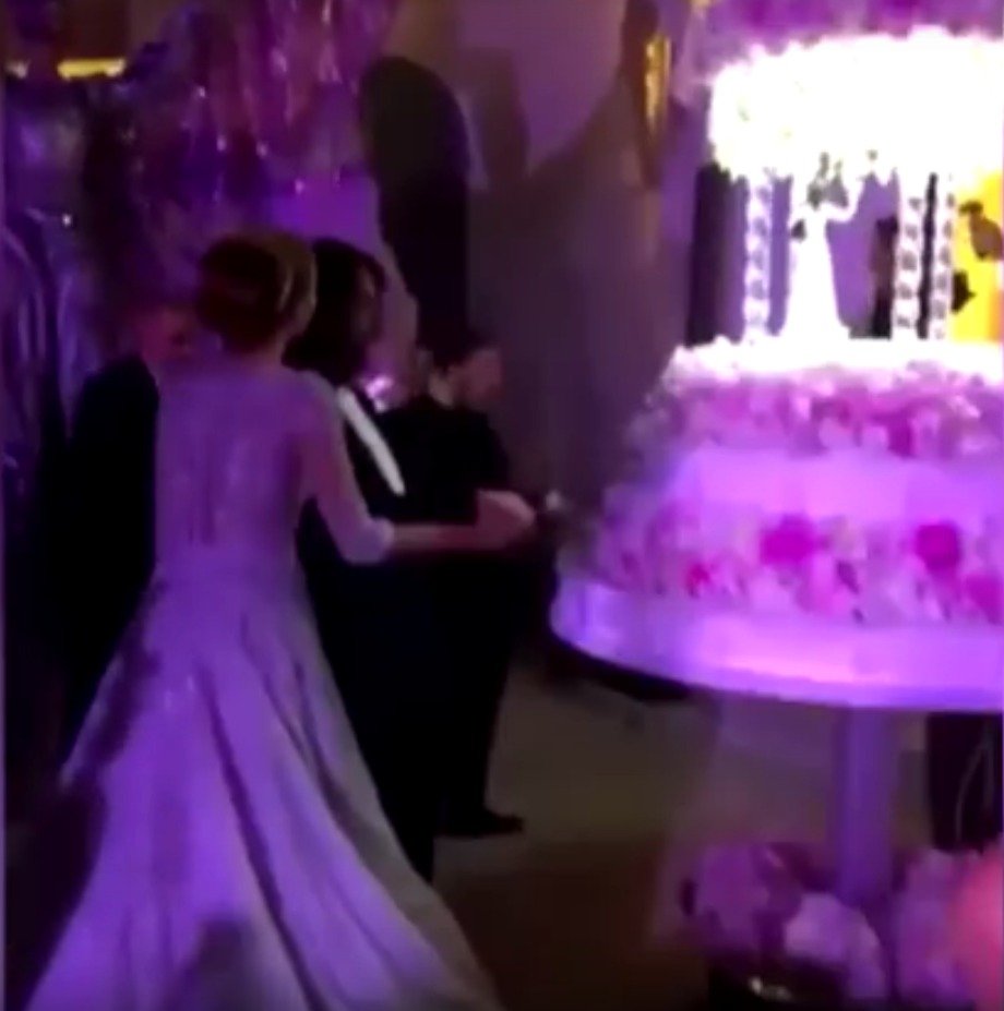 Ženich a nevěsta krájí svatební dort.