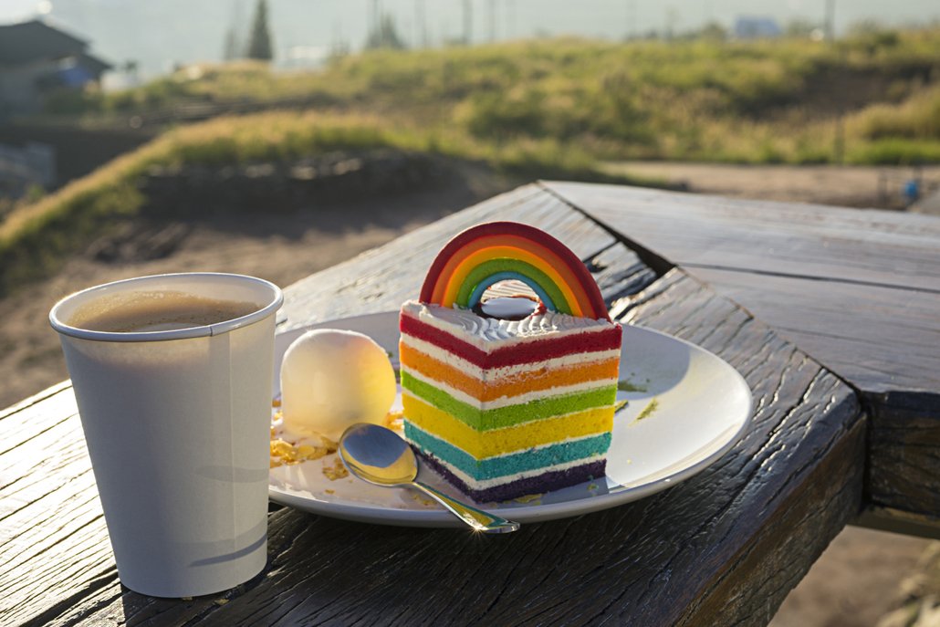 Potřete-li duhový dort krémem, můžete ke zdobení využít ještě cukrářské zdobení ve stejných barevných tónech.