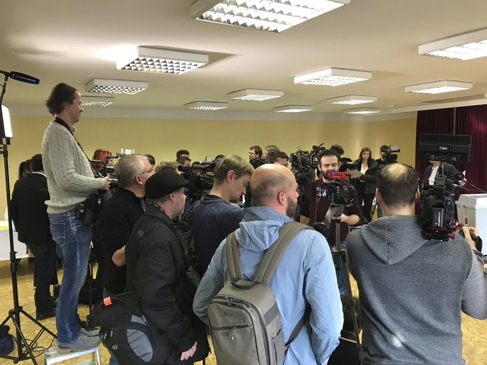 Novináři ve volební místnosti čekající na příjezd Jiřího Drahoše.