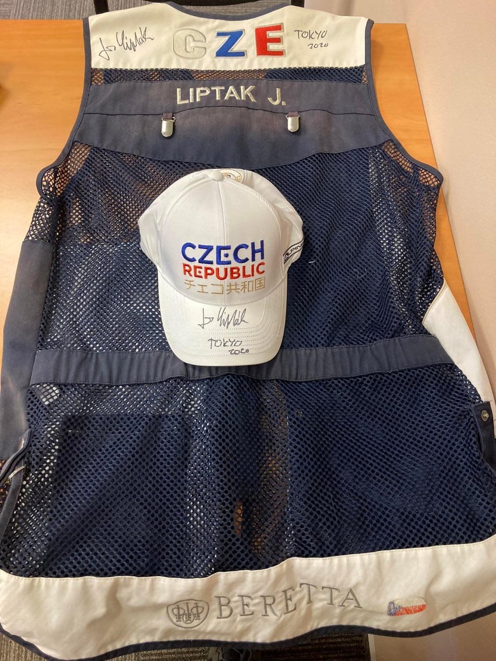 Střeleckou vestu a čepici z Tokia do aukce věnovali olympijští vítězové ve střelbě Jiří Lipták a David Kostelecký.