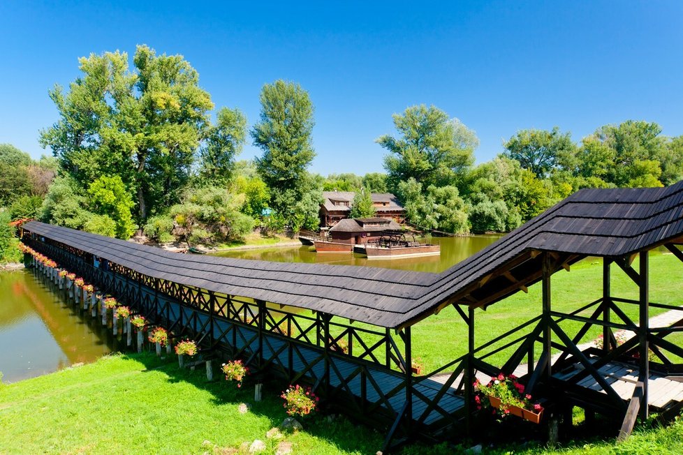 Od vodního mlýnu přes řeku se dostanete přes historický dřevěný most.