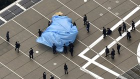 Policie přikrývá plachtou dron, který přistál na střeše u japonského premiéra.