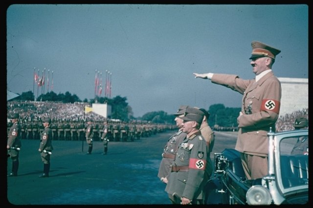 Nacistický pozdrav a Hitlerův úsměv na sjezdu strany NSDAP v roce 1937.