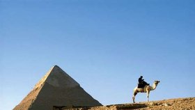 Dvě poznávací znamení Egypta – pyramidy a velbloudi.