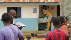 Zdravotníci v Libérii vynášejí z vesnické chýše další oběť eboly.