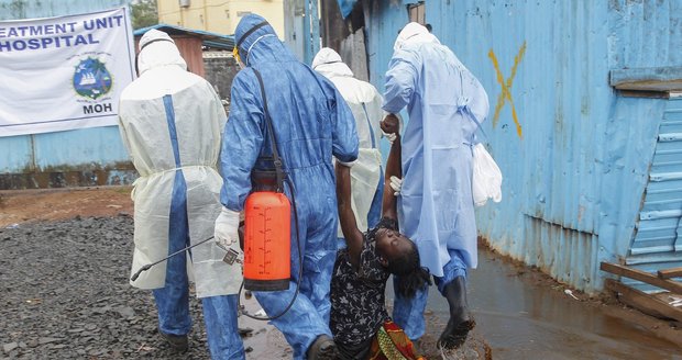 Zdravotníci v ochranných oblecích táhnou pacientku, trpící patrně ebolou