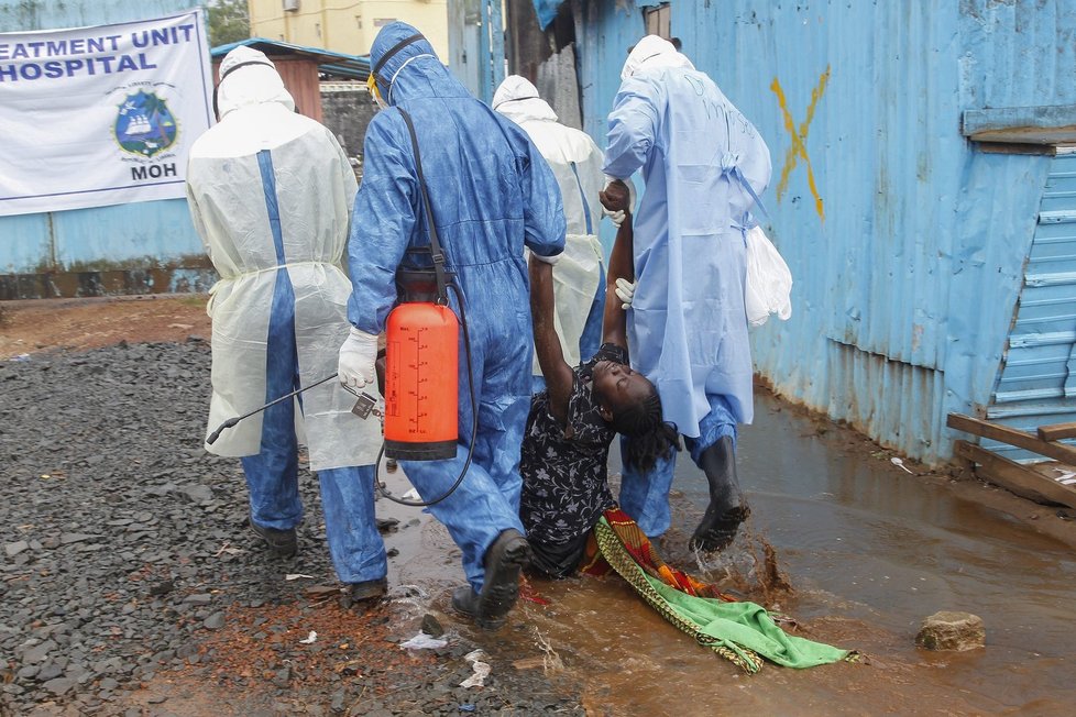 Zdravotníci v ochranných oblecích táhnou pacientku, trpící patrně ebolou