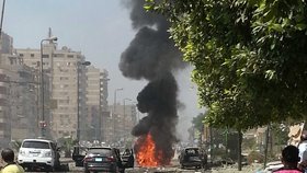 Požár jednoho z aut po pumovém útoku na konvoj ministra vnitra