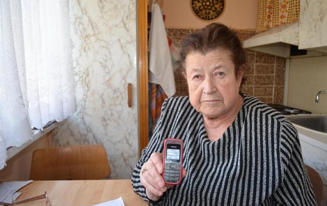 Anna Fendrštátová ukazuje na mobilu upomínku na splátku na čističku.