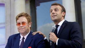 Macron poctil Eltona Řádem čestné legie. „Zachraňme spolu svět před AIDS,“ volají