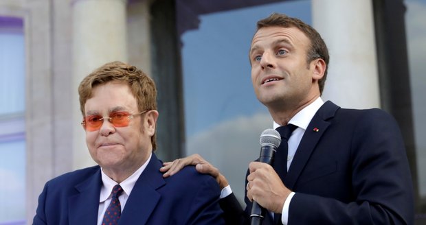 Macron poctil Eltona Řádem čestné legie. „Zachraňme spolu svět před AIDS,“ volají