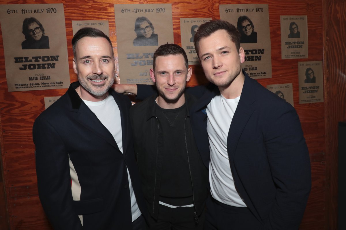 Film Rocketman. Producent David Furnish a herci Jamie Bell a Taron Egerton