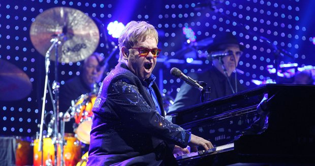 Elton John na pódiu při koncertu.