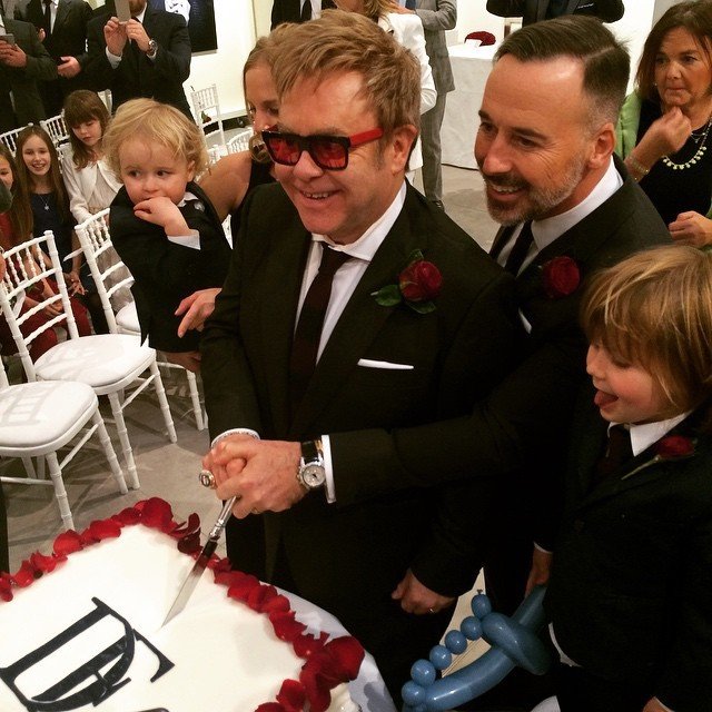 Šťastní novomanželé Elton John a David Furnish právě krájí svatební dort.