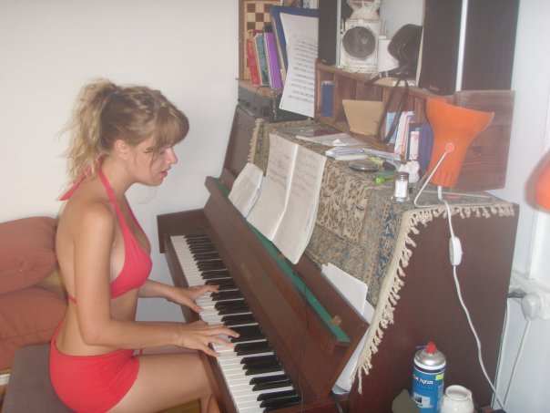 Emma Smetana ve svém bytě hraje na piáno v jen plavkách.