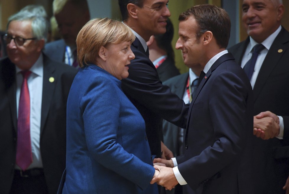Francouzský prezident na summitu EU v Bruselu. Na snímku se vítá s německou kancléřkou Angelou Merkelovou.