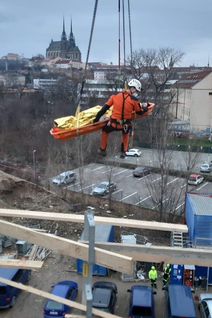 Ke snesení transportní vany se zraněným využili hasiči pohotově jeřáb na staveništi.