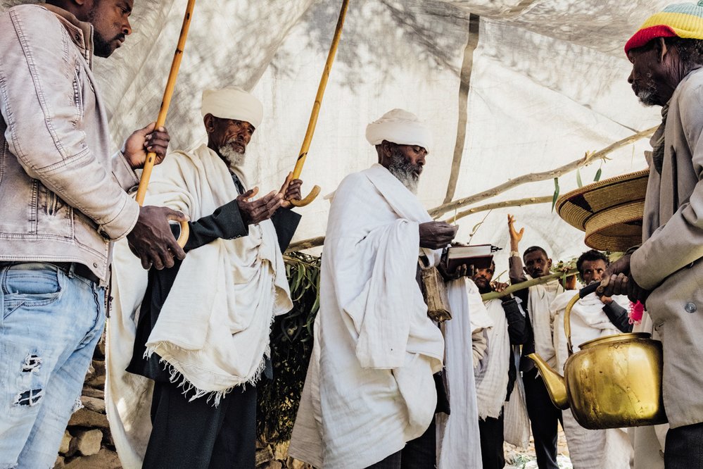 Náboženské setkání mužů ve vesnici Dega s místním knězem