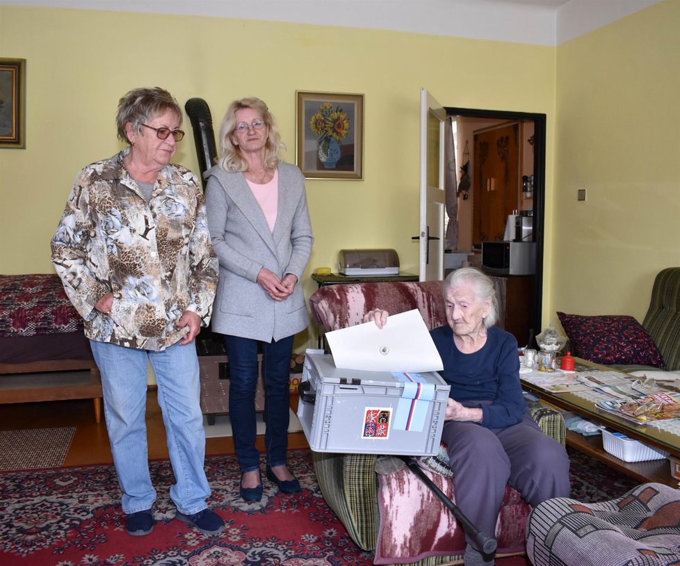 Členky volební komise v Plzni Zdeňka Srpová (79, vlevo) a Marie Matějková (62) přinesly volební urnu Marii Macákové (103) domů. Seniorka již špatně chodí.