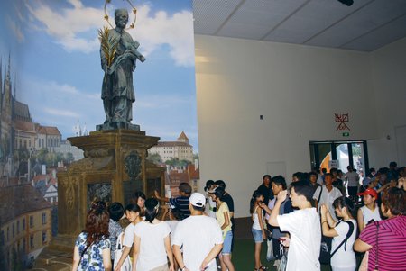 DOTEK ŠTĚSTÍ: Viditelný úspěch má i pozadí Hradčan a kopie sochy Jana Nepomuckého z Karlova mostu se slavnou destičkou s reliéfem pro štěstí.