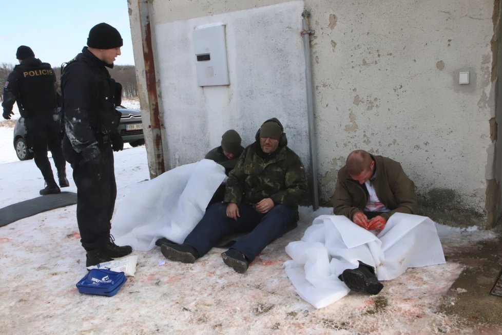 Policista kontroluje, zda zranění narkomani nepotřebují pomoc.