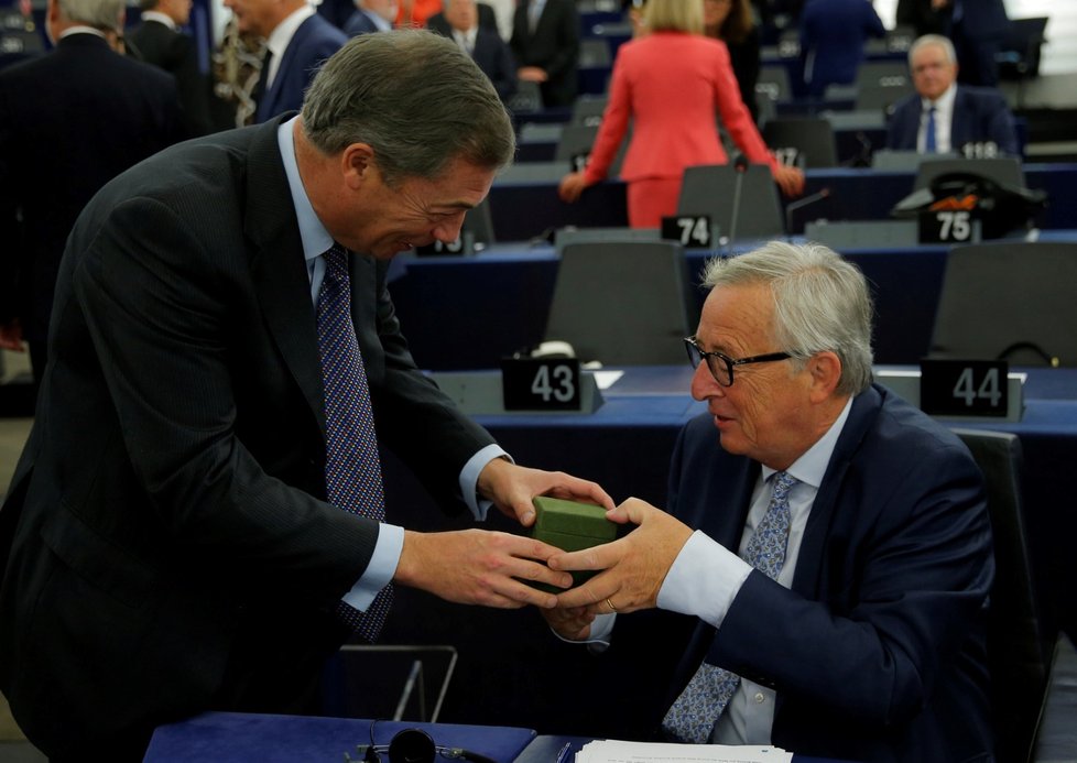 „Pan brexit“ Nigel Farage předává svůj dárek předsedovi Komise Junckerovi během zasedání, na kterém Juncker naposledy zpravil poslance o stavu Unie.