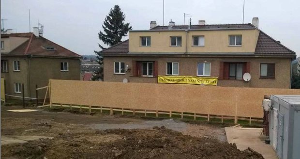 Lidé si na protest proti stavbě vyvěsili na dům transparent.