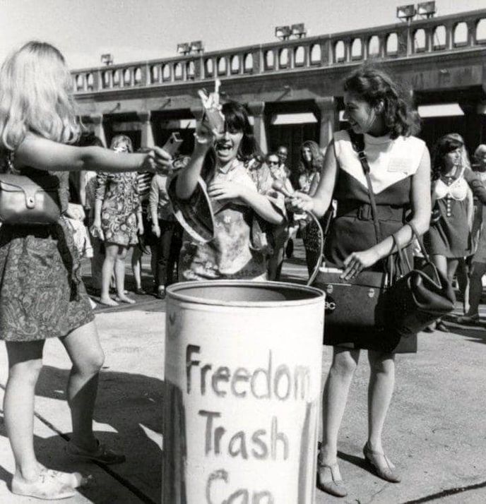 Účastnice feministické demonstrace na Miss America 1969 vyhazují podprsenky do koše.