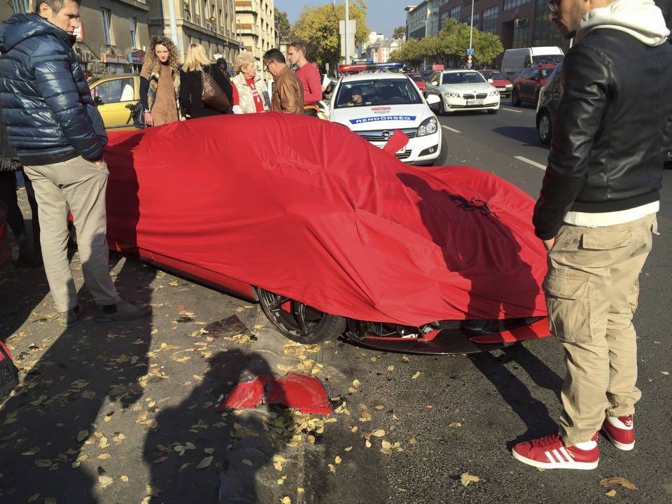 Řidič své nabourané ferrari poté nechal překrýt plachtou.