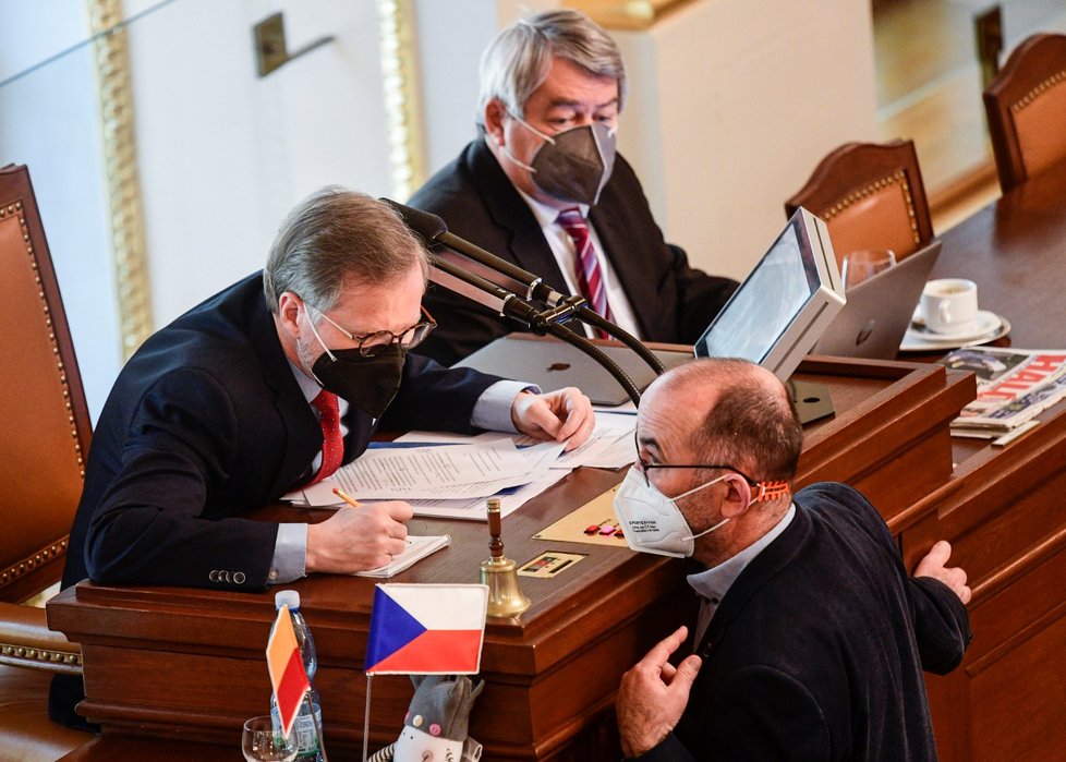 Ministr zdravotnictví za ANO Jan Blatný (vpravo) hovoří s předsedou ODS Petrem Fialou na schůzi Poslanecké sněmovny. Vzadu uprostřed je předseda KSČM Vojtěch Filip (26. 3. 2021)