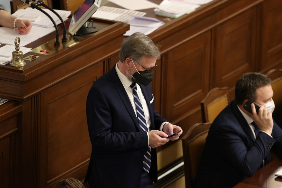 Premiér Petr Fiala (ODS) ve Sněmovně často telefonoval a četl zprávy v telefonu.