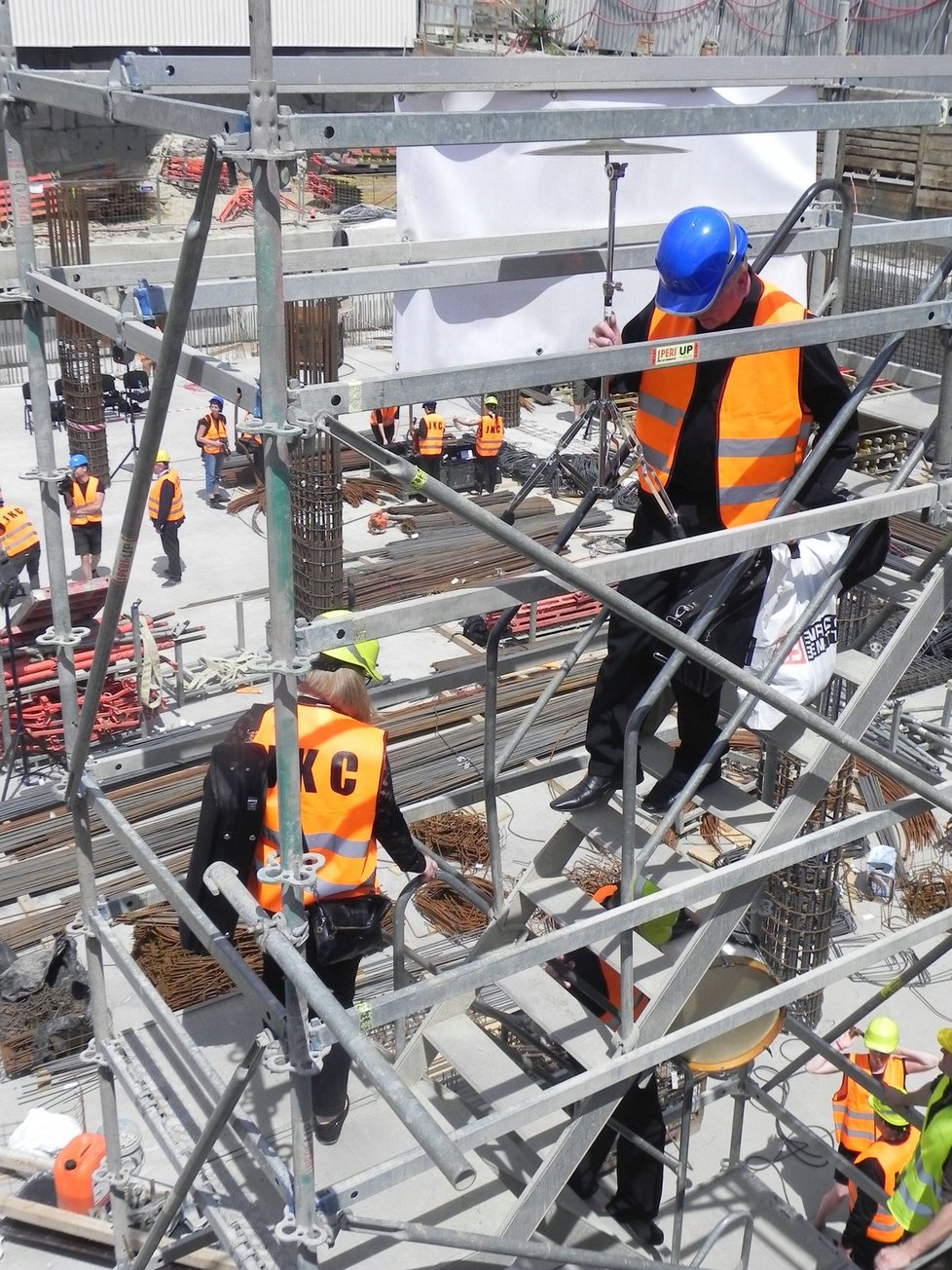 Filharmonici opatrně sestupují do stavební jámy.