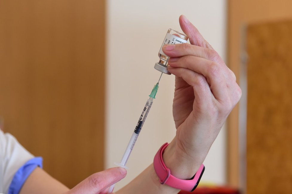 Zdravotnice natahuje vakcínu AstraZeneca do injekční stříkačky v sokolovně v Konici na Prostějovsku, kde mobilní očkovací tým Fakultní nemocnice Olomouc očkoval seniory proti covidu-19 (23. 2. 2021)