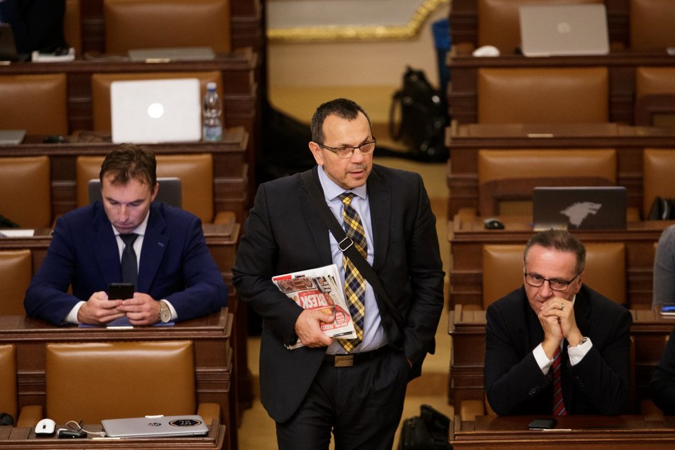 Místopředseda ČSSD Jaroslav Foldyna opouští prořídlý jednací sál Poslanecké sněmovny. Poslanci mají hlasovat o nedůvěře vládě - ta ale hlasování nejspíš ustojí