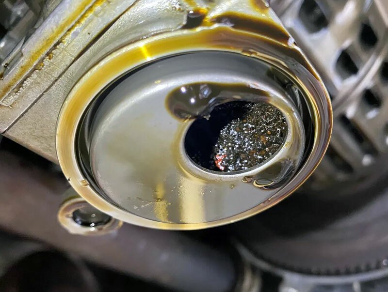 Typický příklad sacího koše olejového čerpadla ucpaného kousky řemene. Výsledkem může být zadřený motor.