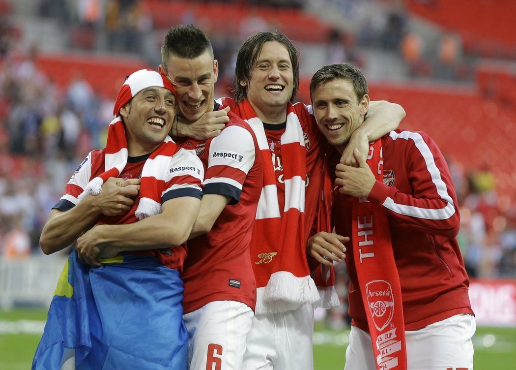 Záložník Arsenalu Tomáš Rosický v obklopení se spoluhráči slaví triumf v Anglickém poháru
