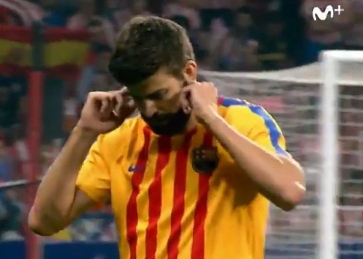 Obránce Barcelony Gerard Piqué si při odchodu z rozcvičení na stadionu Atlétika Madrid zacpal uši