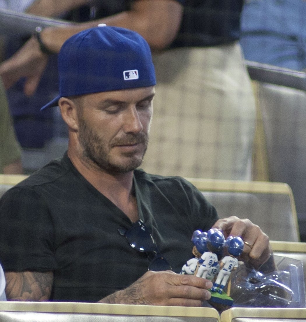 Dění na hřišti asi nebylo moc zábavné. David Beckham si během zápasu LA Dodgers hrál raději s plastovými panáčky.