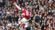Útočník Arsenalu Lukas Podolski v souboji s obráncem Liverpoolu Johnem Flanaganem