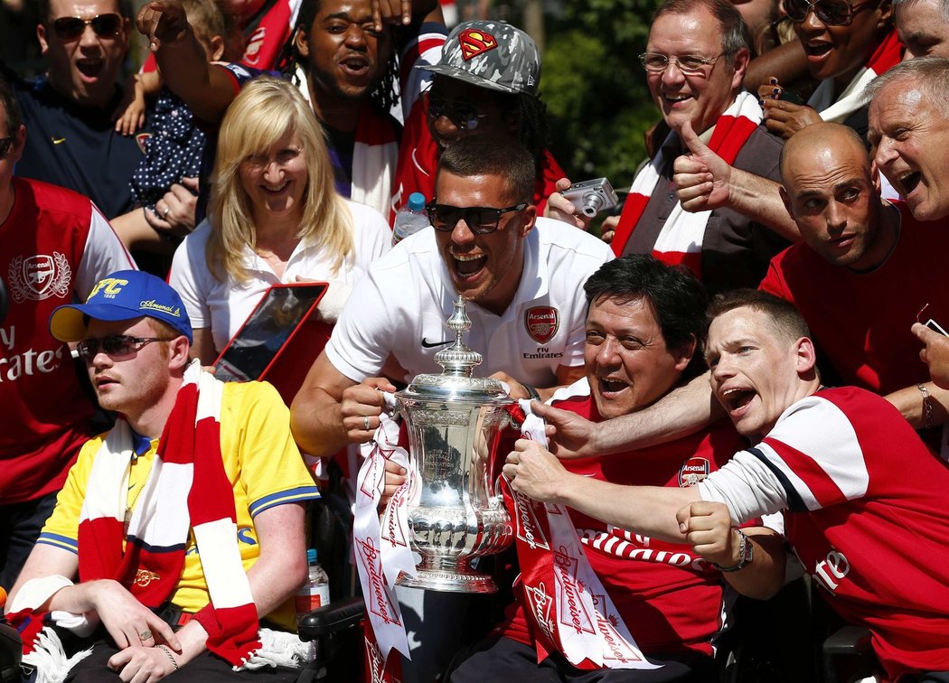 Útočník Arsenalu Lukas Podolski se ochotně vyfotil s trofejí i fanoušky