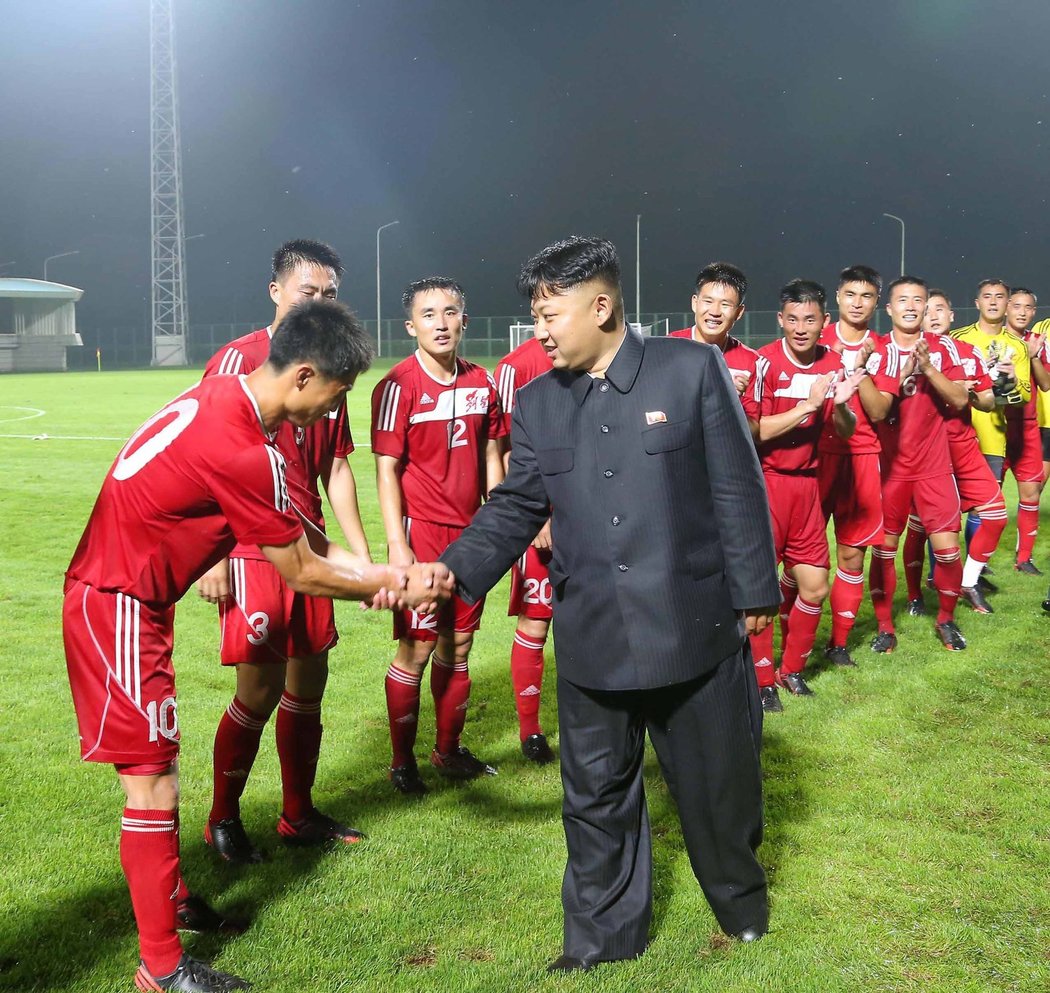 Kim Čong-un je známý sportovní fanoušek. Na snímku při setkání s fotbalisty jednoho ze severokorejských ligových týmů.