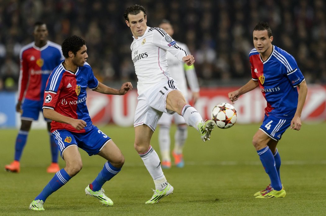 Záložník Realu Madrid Gareth Bale při práci s míčem v obklopení hráčů Basileje