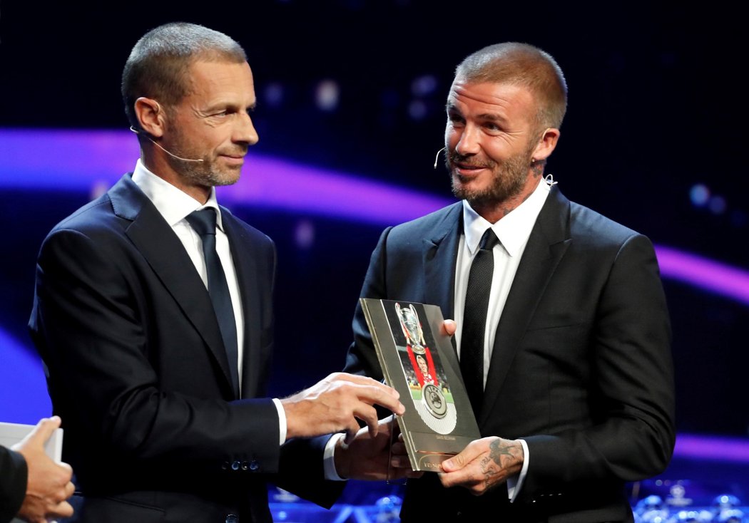 David Beckham přebírá cenu od prezidenta UEFA Aleksandera Ceferina během losu základních skupin Ligy mistrů